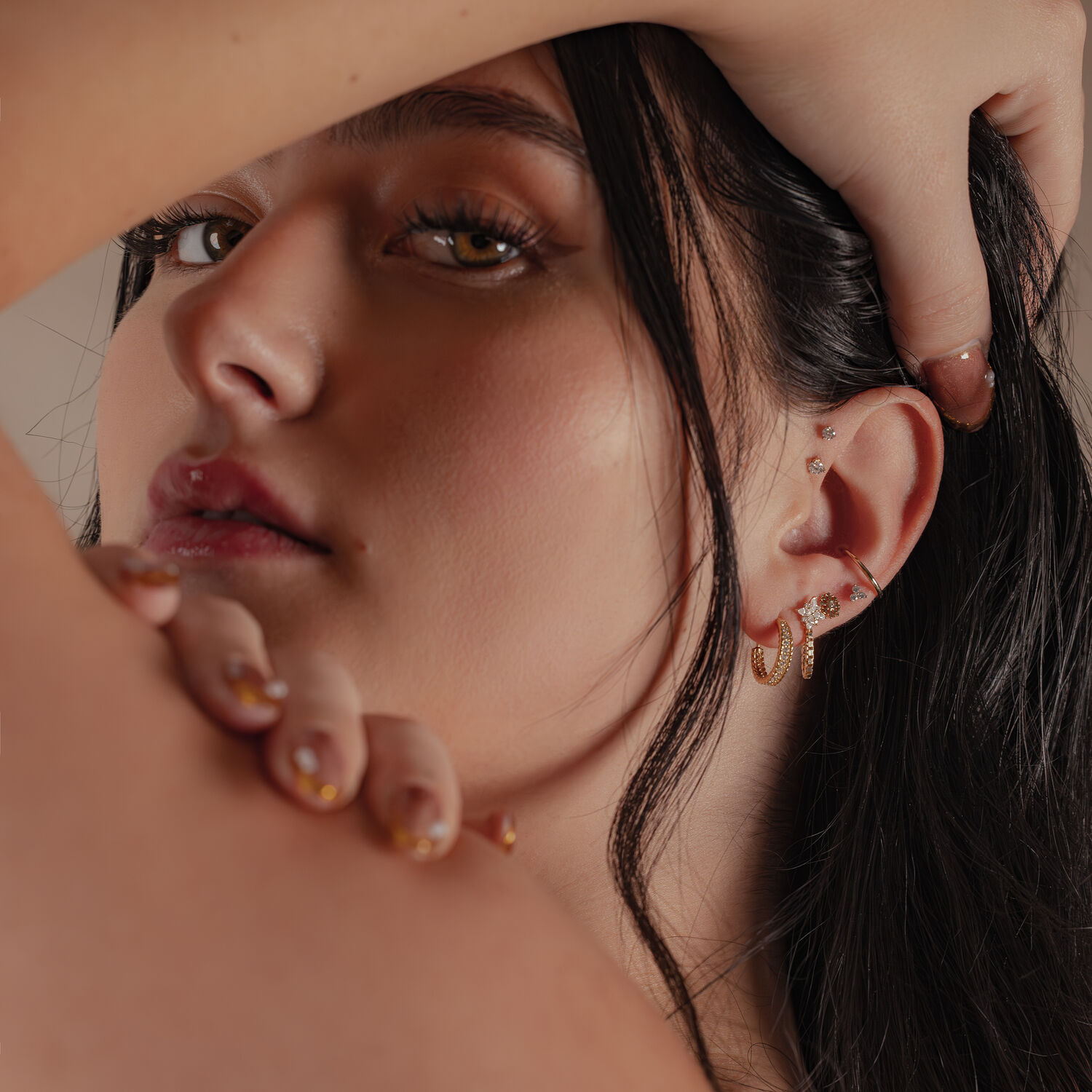 Élégant embout en or avec moissanite à l'oreille Gros plan d'une femme avec un embout en or 14K avec moissanite à l'oreille, arrière-plan flou