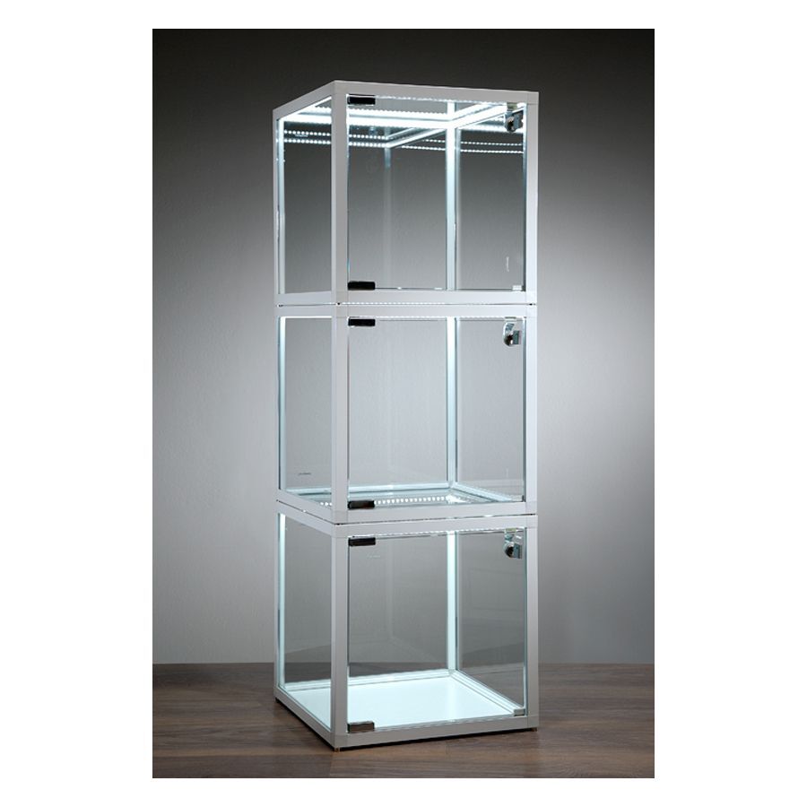 Cube vitrine blanc avec éclairage LED Trois cubes vitrines blancs en verre avec bandes LED sur table en bois