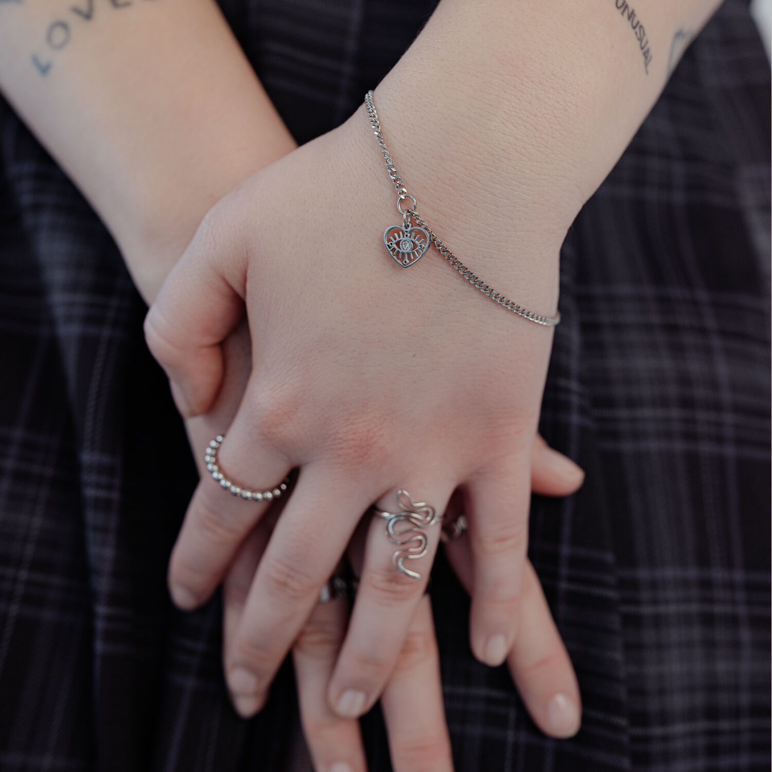 Bracelet en argent élégant avec pendentif cœur Bracelet en argent avec pendentif cœur au poignet, porté par une personne.