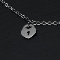 Bracelet argenté avec pendentif cadenas cœur Bracelet argenté avec pendentif cadenas cœur sur fond noir