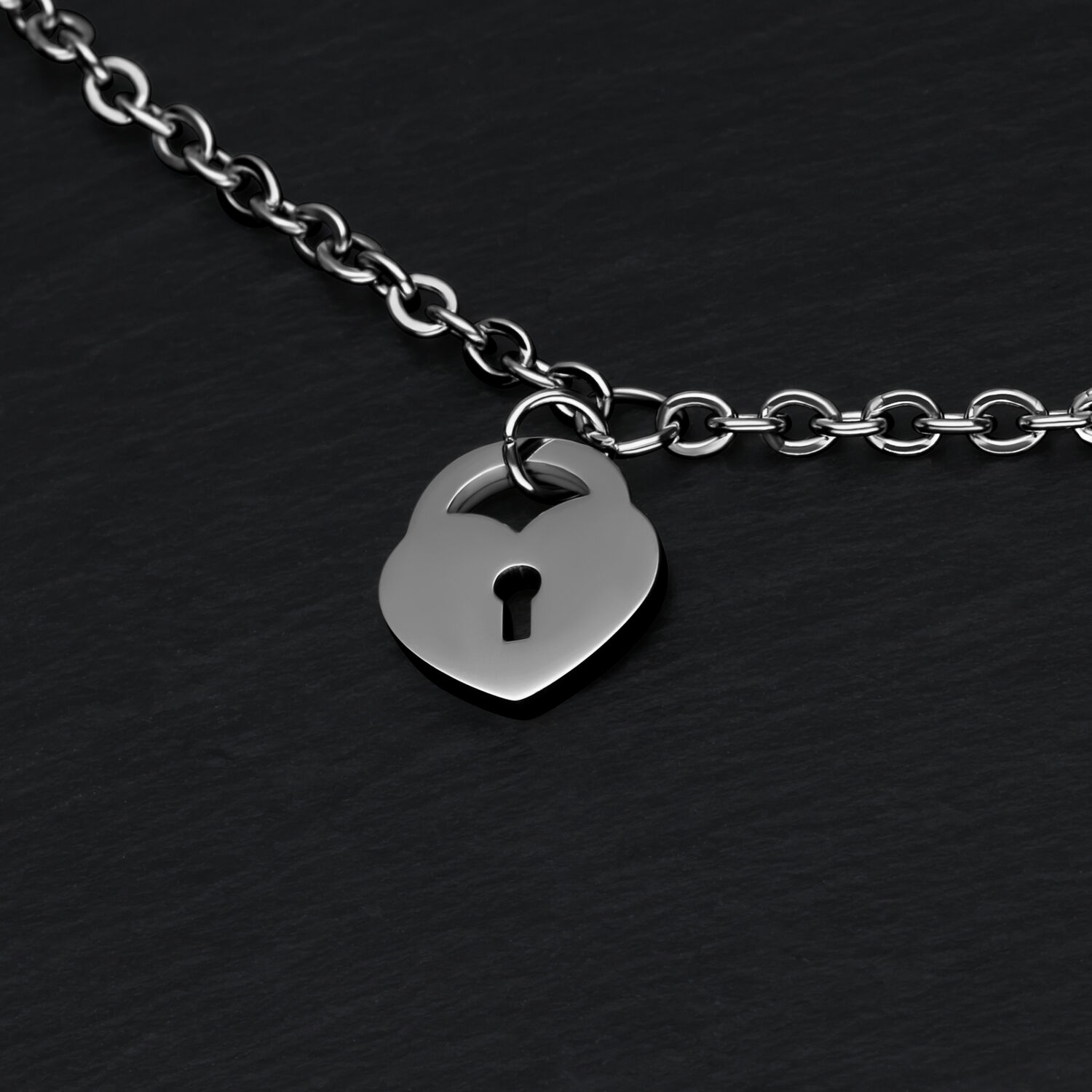 Bracelet argenté avec pendentif cadenas cœur Bracelet argenté avec pendentif cadenas cœur sur fond noir