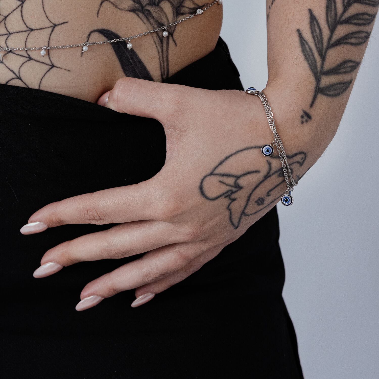 Bracelet en argent avec pendentif Nazar au poignet, main tatouée