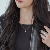 Chaîne Little Snake argentée de Wildcat Femme aux longs cheveux noirs portant une chaîne Little Snake argentée et une veste en cuir noire