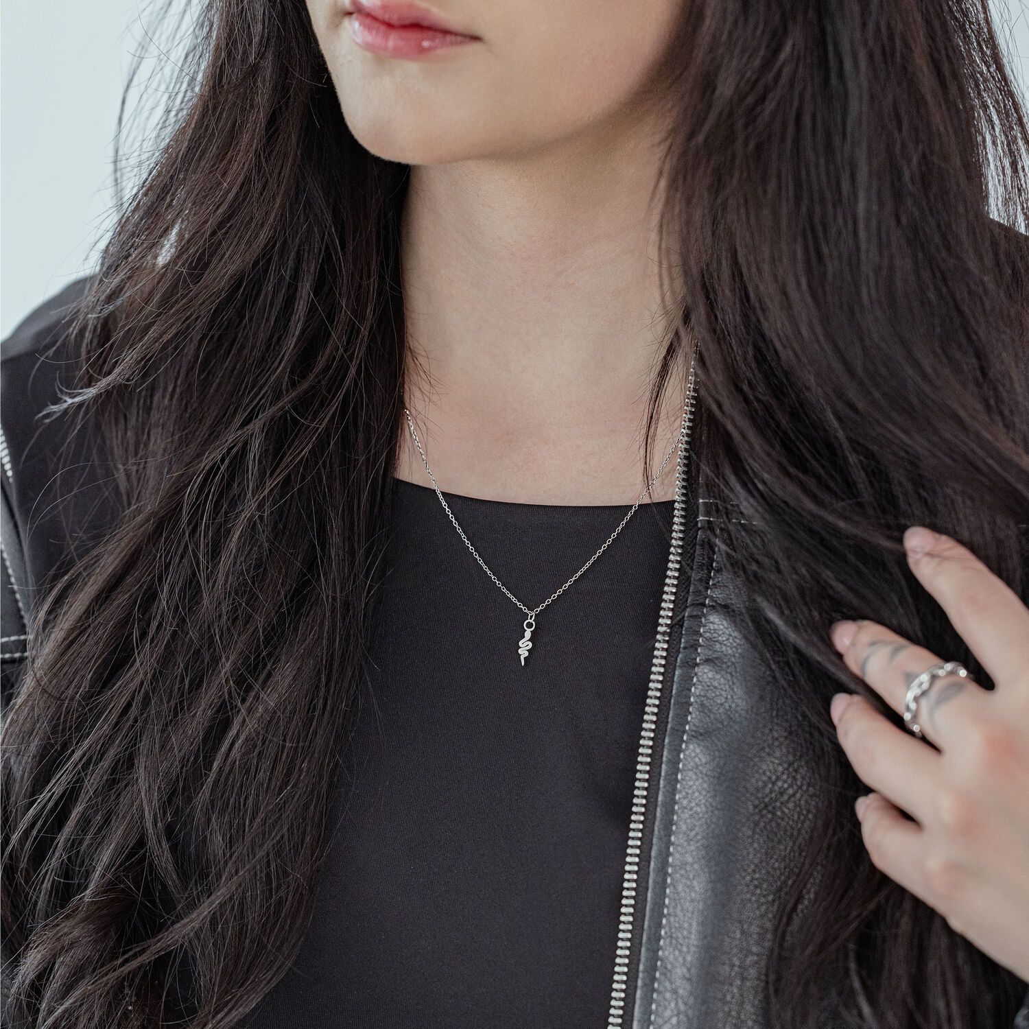 Chaîne Little Snake argentée de Wildcat Femme aux longs cheveux noirs portant une chaîne Little Snake argentée et une veste en cuir noire