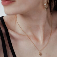 Collier Little Sunflower doré pour femme Femme avec collier Little Sunflower doré, délicat et élégant, sur fond clair