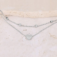 Bracelet argenté à double rangée avec cœur et perles sur fond clair