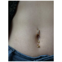 Piercing Micro Bananabell doré au nombril, porté sur peau claire