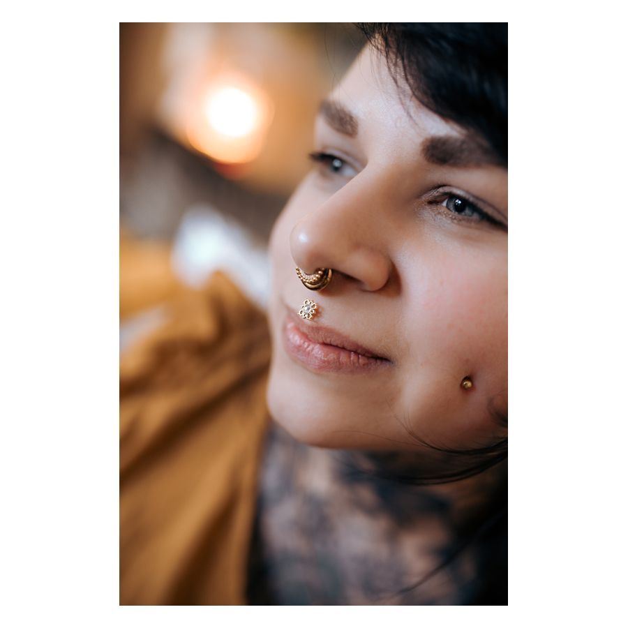Oriental Sun Push-Fit Labret porté à l'oreille Gros plan d'une personne avec un Oriental Sun Push-Fit Labret dans le piercing nasal, couleur dorée