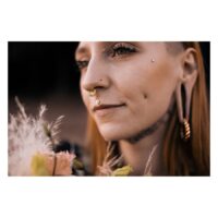 Labret Push-Fit Fleur élégant pour l'oreille Femme avec un labret Push-Fit Fleur dans l'oreille, entourée de fleurs, en plein air