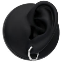 Petites boucles d'oreilles en bambou 10 mm en argent Boucles d'oreilles en bambou argentées sur un modèle d'oreille noir sur fond neutre