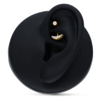 Microbanane en or 18K avec 5 cristaux Microbanane dorée avec des cristaux clairs sur un présentoir d'oreille noir