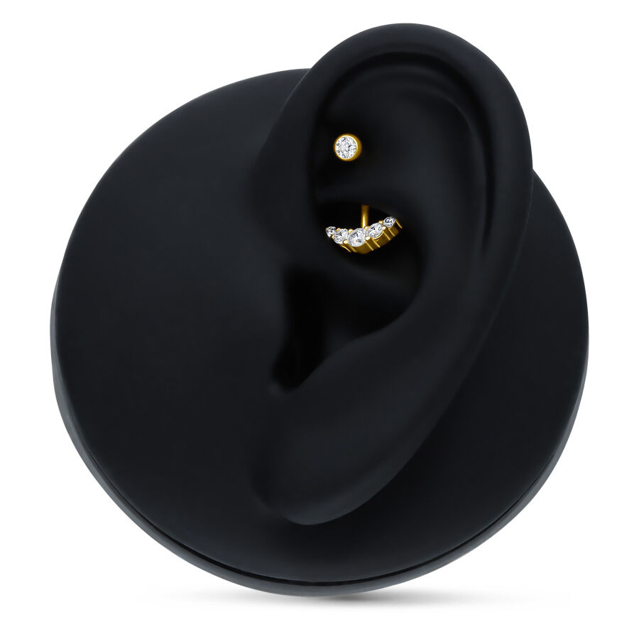 Microbanane en or 18K avec 5 cristaux Microbanane dorée avec des cristaux clairs sur un présentoir d'oreille noir