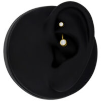 Microbanane en or 18K avec cristal Piercing en or avec cristal clair sur modèle d'oreille noire
