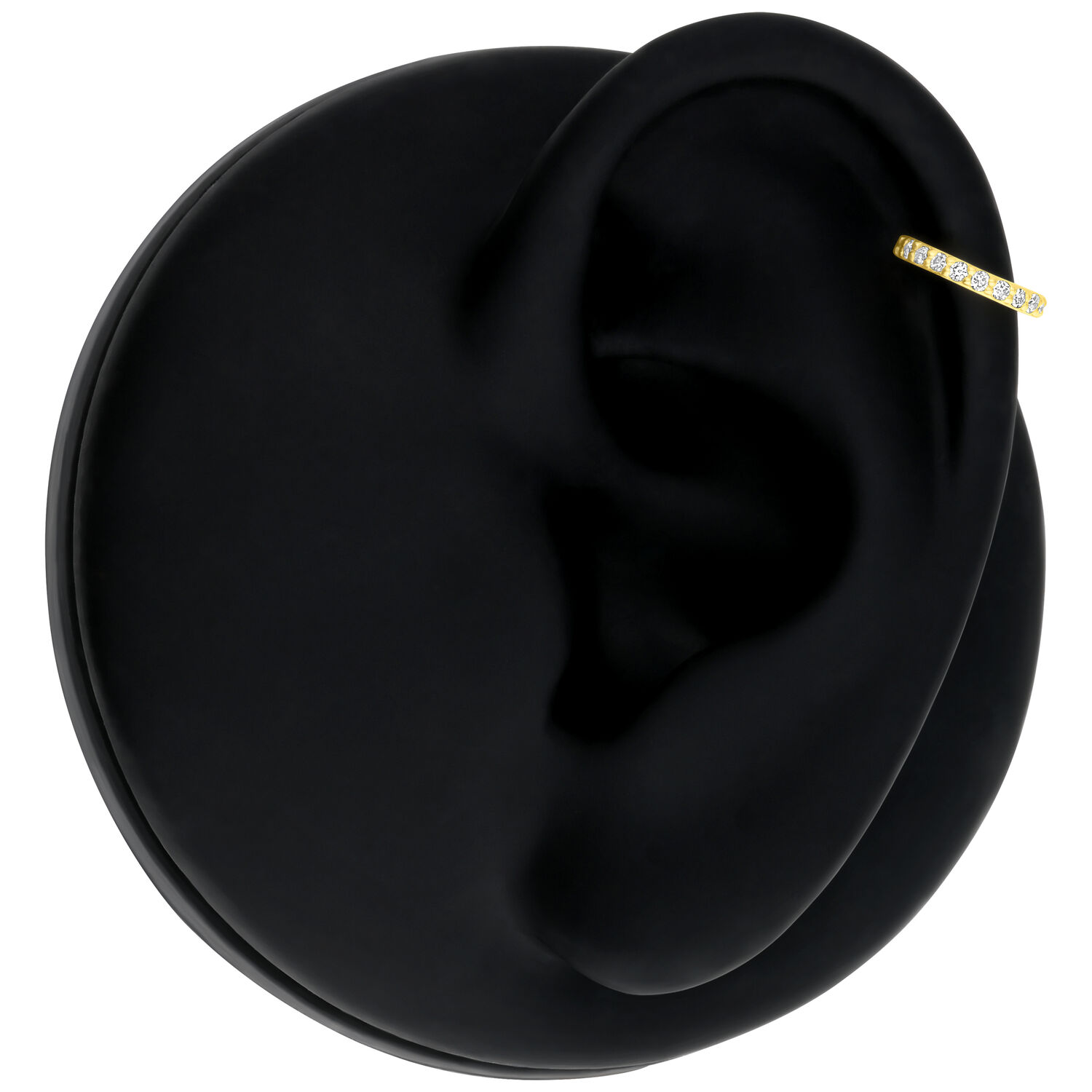 Anneau en or avec diamants sur un modèle d'oreille noire sur fond blanc