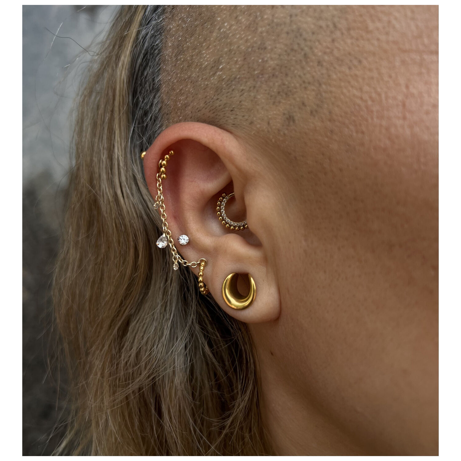 Clicker en or 14K avec cristaux Piercing à l'oreille avec clicker en or 14K et cristaux clairs, photographié de côté