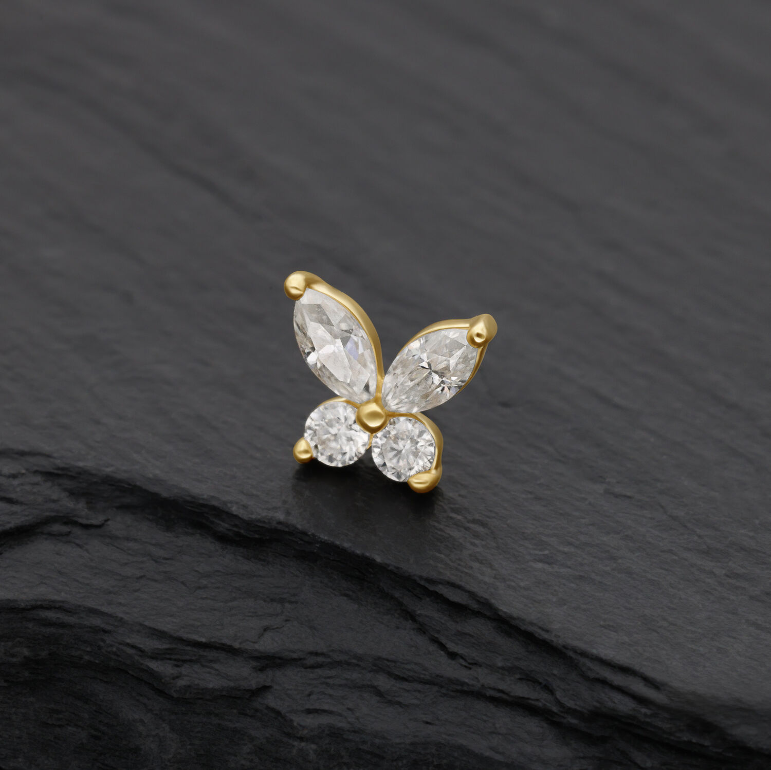 Embout papillon en or avec pierres de moissanite claires sur fond noir