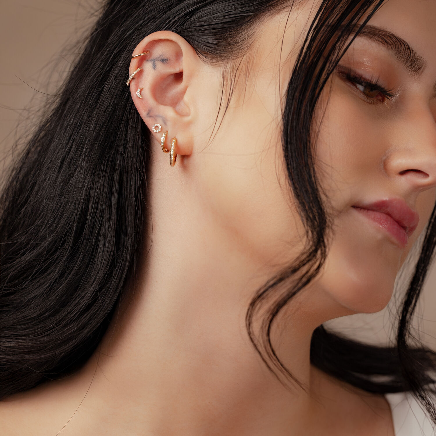 Embout Lune en Or 14K avec Moissanite Femme avec embout lune en or 14K avec moissanite dans l'oreille sur fond neutre
