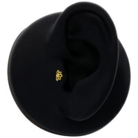 Embout Lotus en or 14K sur modèle d'oreille noire, vue de face