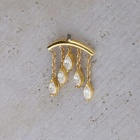 Embout Helix en or 18K avec pendentifs en cristal Embout Helix doré avec cinq pendentifs en cristal clair sur fond béton