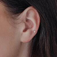 Embout d'oreille en or 14K avec opale Embout ovale en or avec opale synthétique dans l'oreille sur fond clair