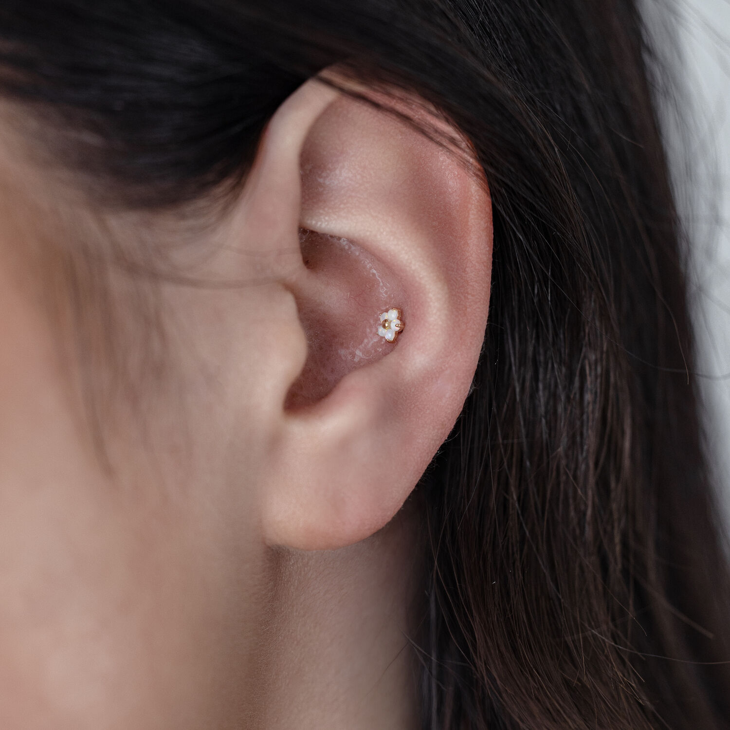 14K Or Fleur Opale Embout à l'Oreille Gros plan d'une oreille avec un embout en or 14K fleur opale