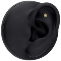 Embout fleur en or 14K avec moissanite pour oreille Embout fleur en or 14K avec moissanite sur modèle d'oreille noir