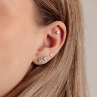 Disque argenté pour triple piercing 4,0 mm Gros plan d'une oreille avec un disque argenté pour triple piercing de 4,0 mm sur fond clair