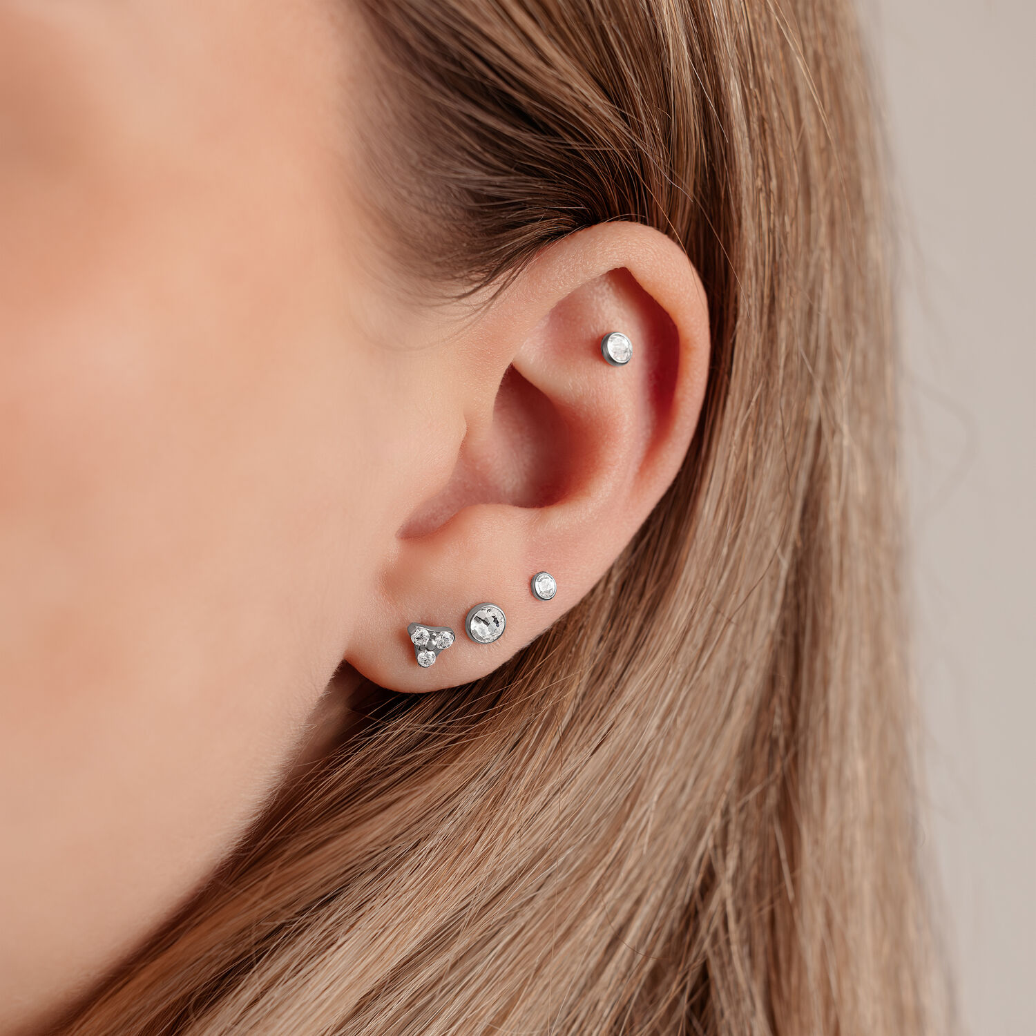 Disque argenté pour triple piercing 4,0 mm Gros plan d'une oreille avec un disque argenté pour triple piercing de 4,0 mm sur fond clair