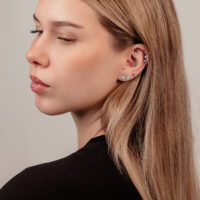 Boule de cristal pour labrets en différentes couleurs Femme avec plusieurs piercings et boucle d'oreille boule de cristal sur fond clair
