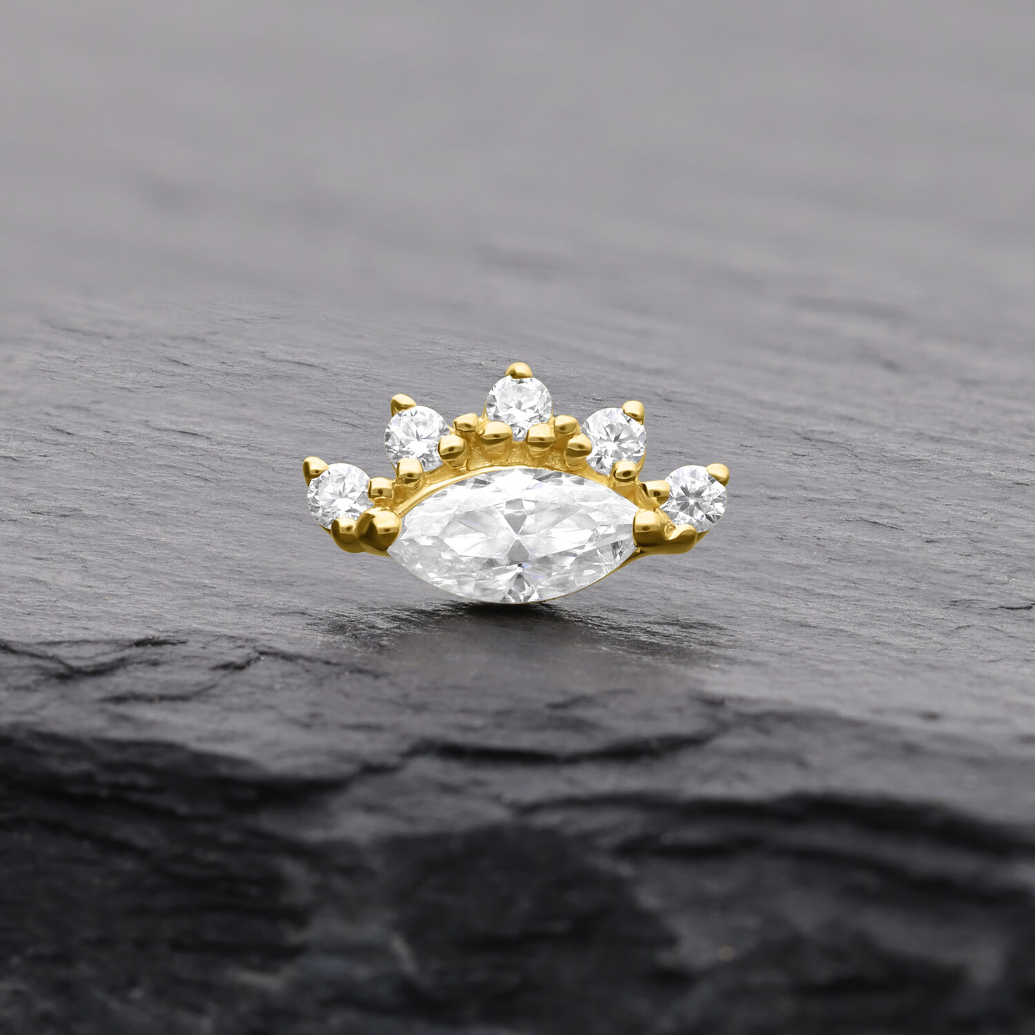 Embout moissanite doré avec cinq pierres sur fond sombre