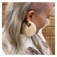 Grands poids d'oreille en bois beige Poids d'oreille en bois beige avec motif circulaire à l'oreille d'une personne devant un fond de bambou