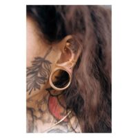 Piercing Micro Bananabell stylé en or rose Piercing Bananabell en or rose dans l'oreille avec tatouage en arrière-plan
