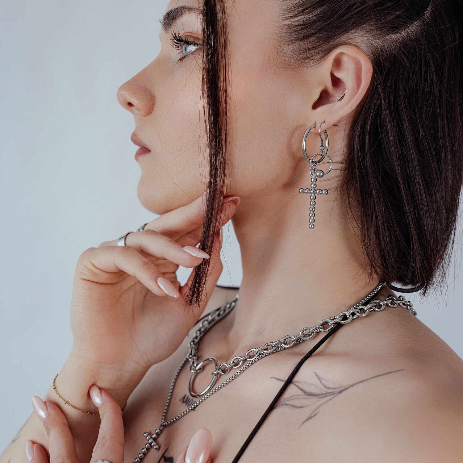 Femme avec des boucles d'oreilles Bubble Cross Hoops en argent, profil latéral