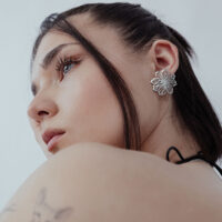 Boucles d'oreilles fleurs élégantes en acier inoxydable Femme avec des boucles d'oreilles fleurs élégantes en acier inoxydable argenté sur fond blanc