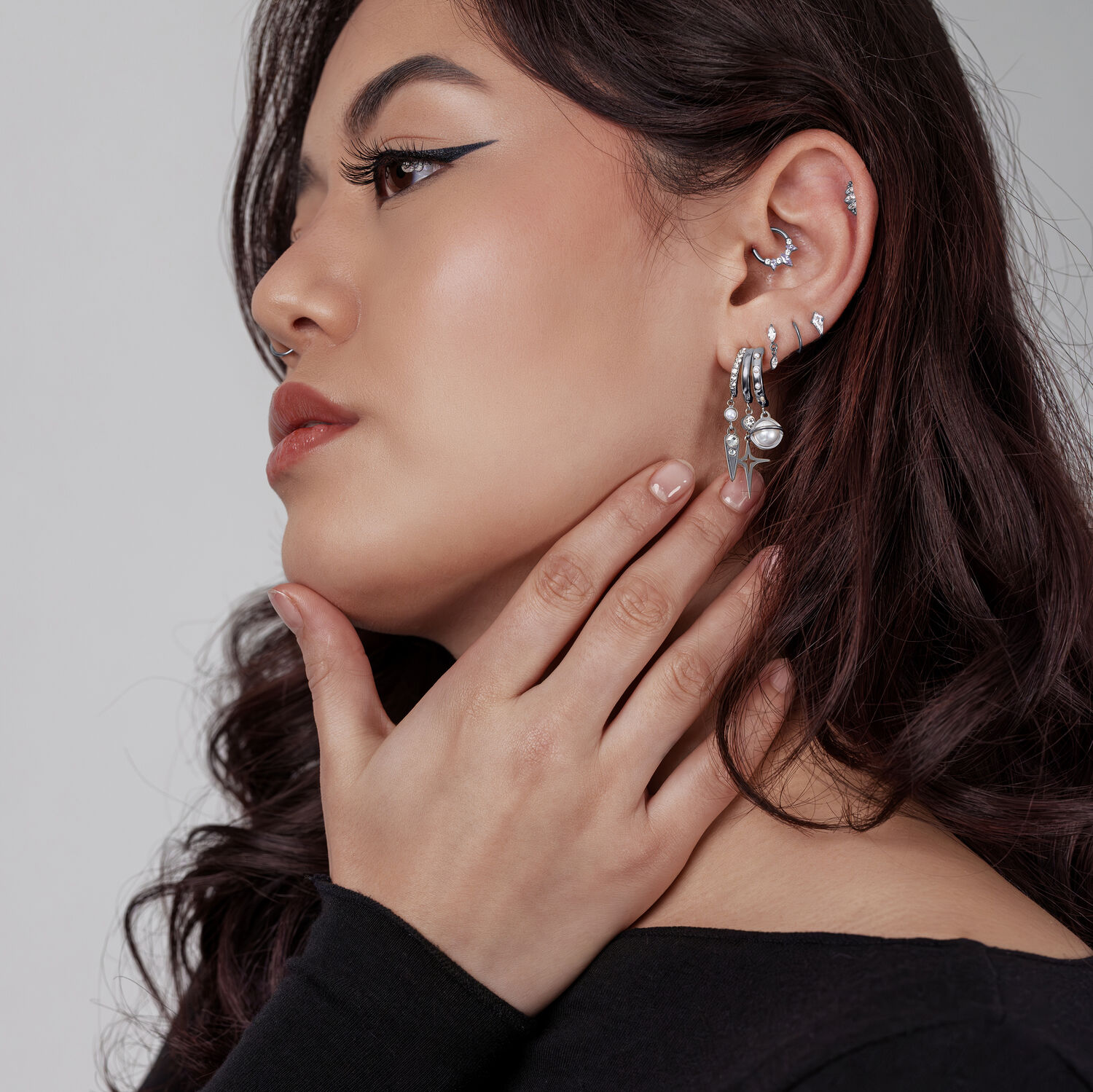 Femme avec plusieurs clous d'oreilles et bagues en argent, profil latéral