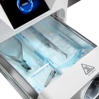 Enbio Autoclave S avec compartiment ouvert, rempli d'outils de stérilisation sur fond blanc