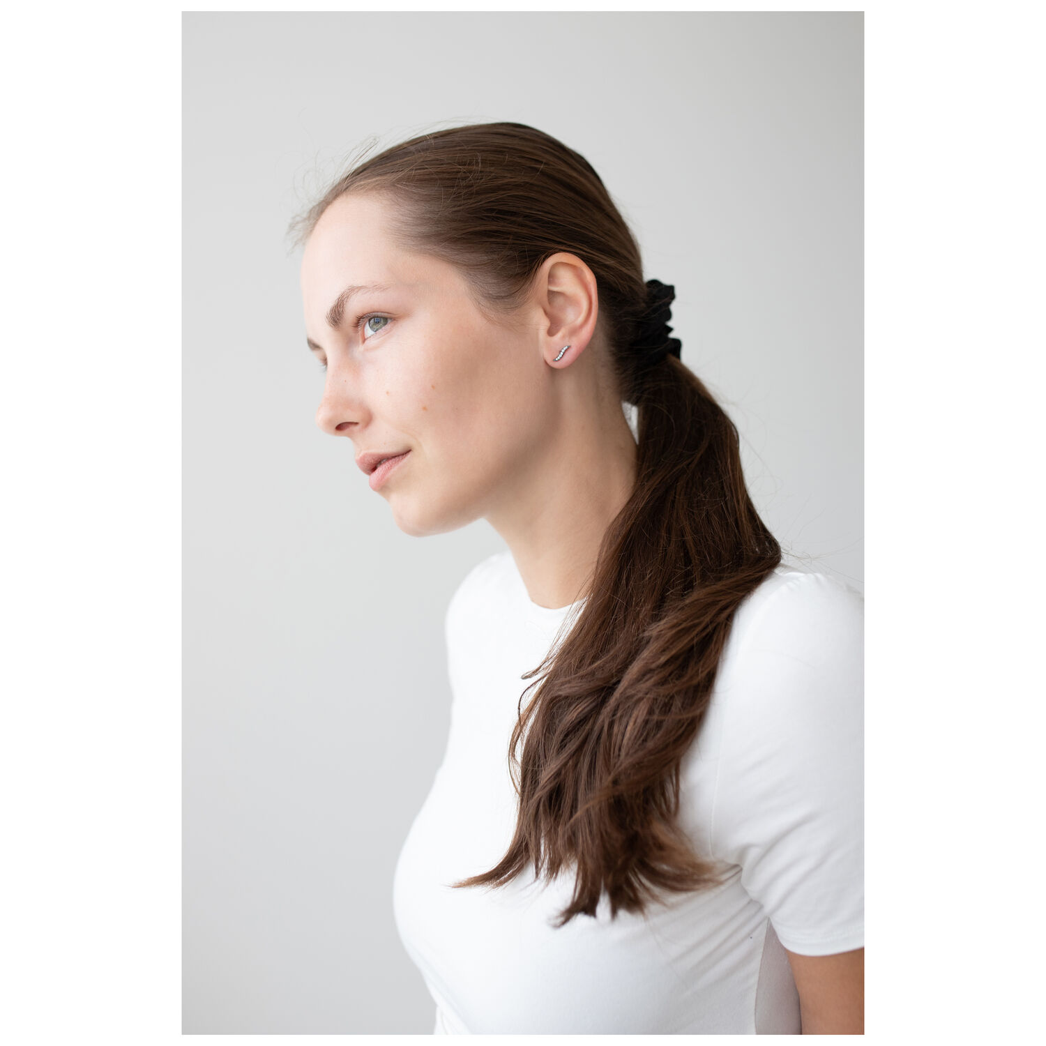 Femme avec boucles d'oreilles en cristal noir, profil latéral