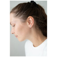 Boucles d'oreilles Double Beam Crystal accrocheuses Boucles d'oreilles en argent avec cristaux sur l'oreille d'une femme sur fond neutre