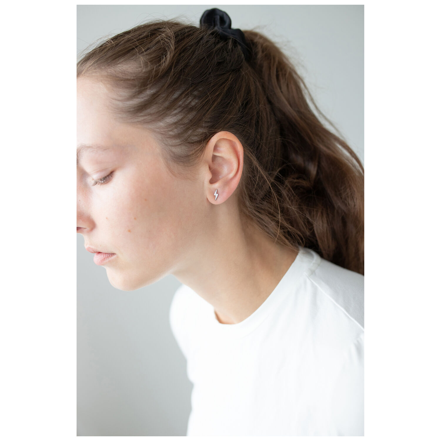 Boucles d'oreilles en cristal élégantes en argent Femme aux longs cheveux portant des boucles d'oreilles en cristal argentées