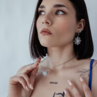 Collier gravable en acier chirurgical avec pendentif cœur Femme portant un collier argenté avec pendentif cœur gravable sur fond neutre