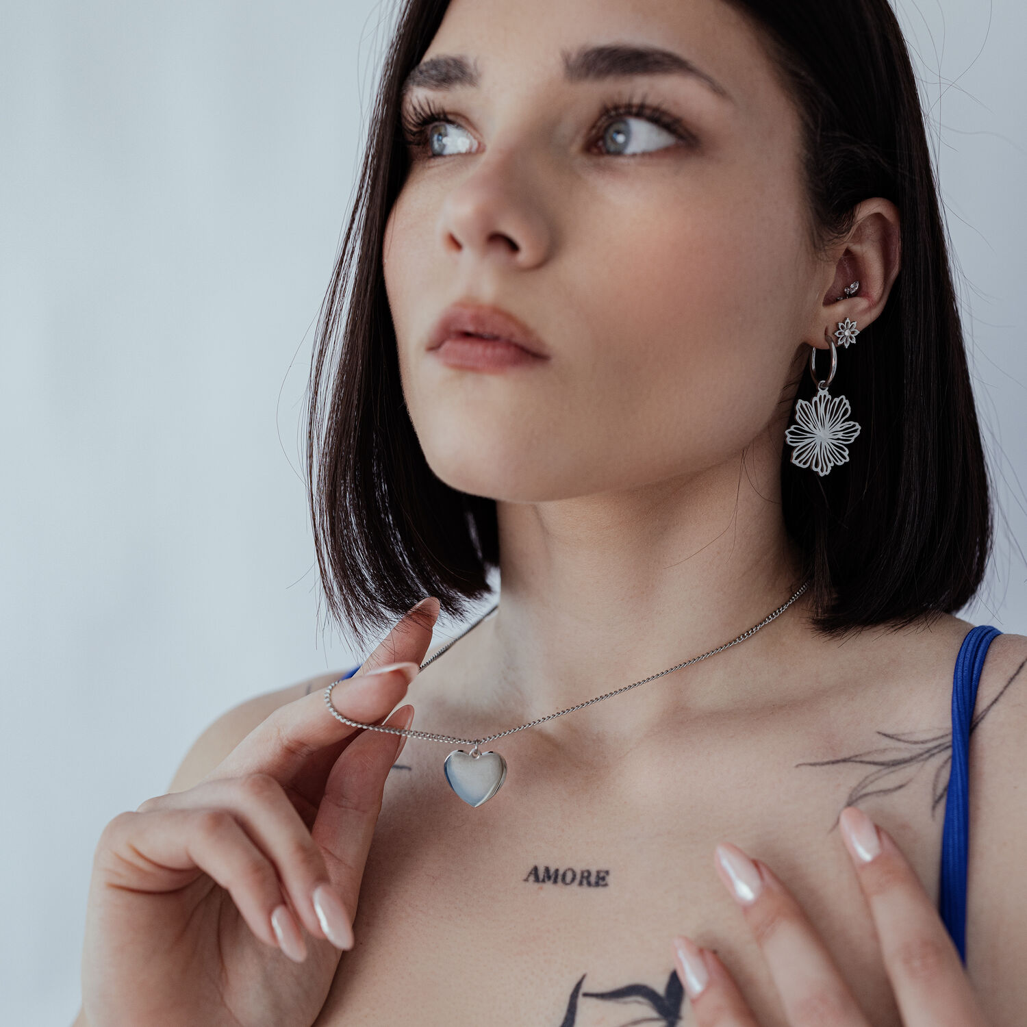 Collier gravable en acier chirurgical avec pendentif cœur Femme portant un collier argenté avec pendentif cœur gravable sur fond neutre