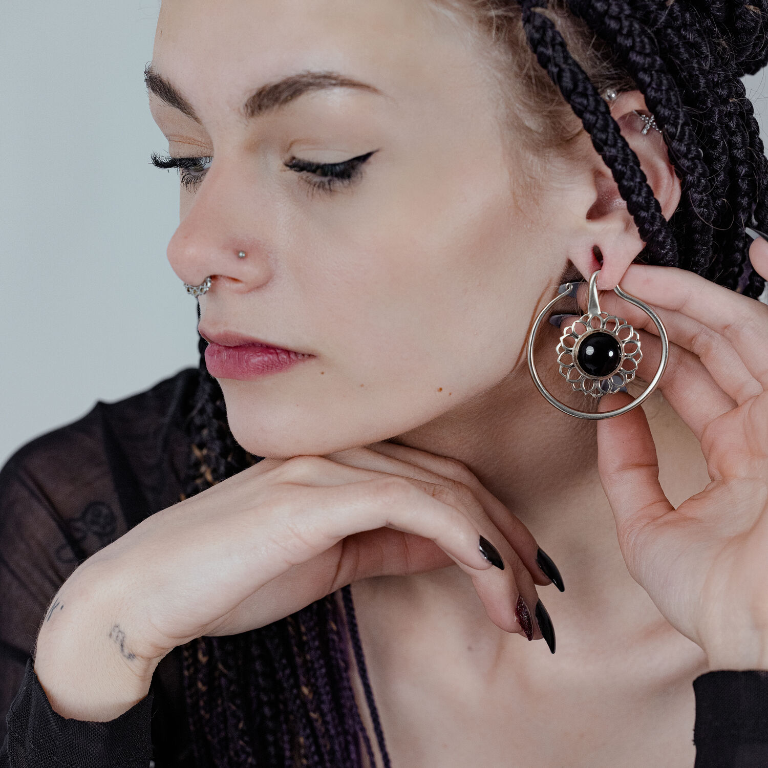 Poids d'oreille en argent avec onyx noir Femme avec des poids d'oreille en laiton argenté et onyx noir sur fond clair