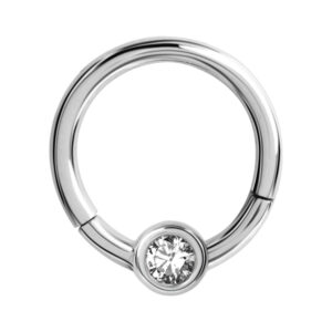 Anneau de piercing argenté avec cristal clair sur fond blanc