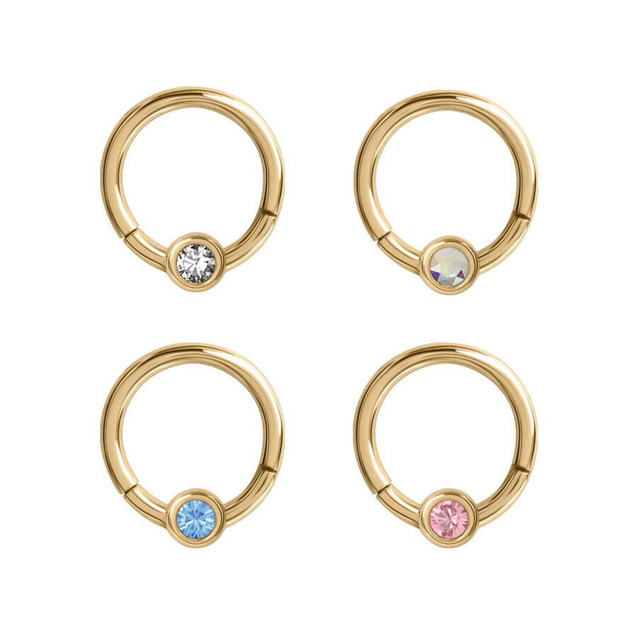 Clicker en cristal doré avec cristaux colorés Quatre anneaux de piercing dorés avec des cristaux clairs, bleus, roses et chatoyants sur fond blanc
