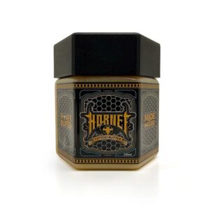 Pot noir et doré de Hornet Honey Butter sur fond blanc