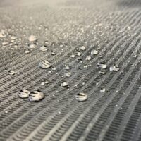 Rouleau de couverture noir imperméable, gros plan Gros plan d'un rouleau de couverture noir imperméable avec des gouttes d'eau