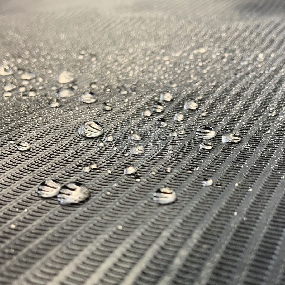 Rouleau de couverture noir imperméable, gros plan Gros plan d'un rouleau de couverture noir imperméable avec des gouttes d'eau