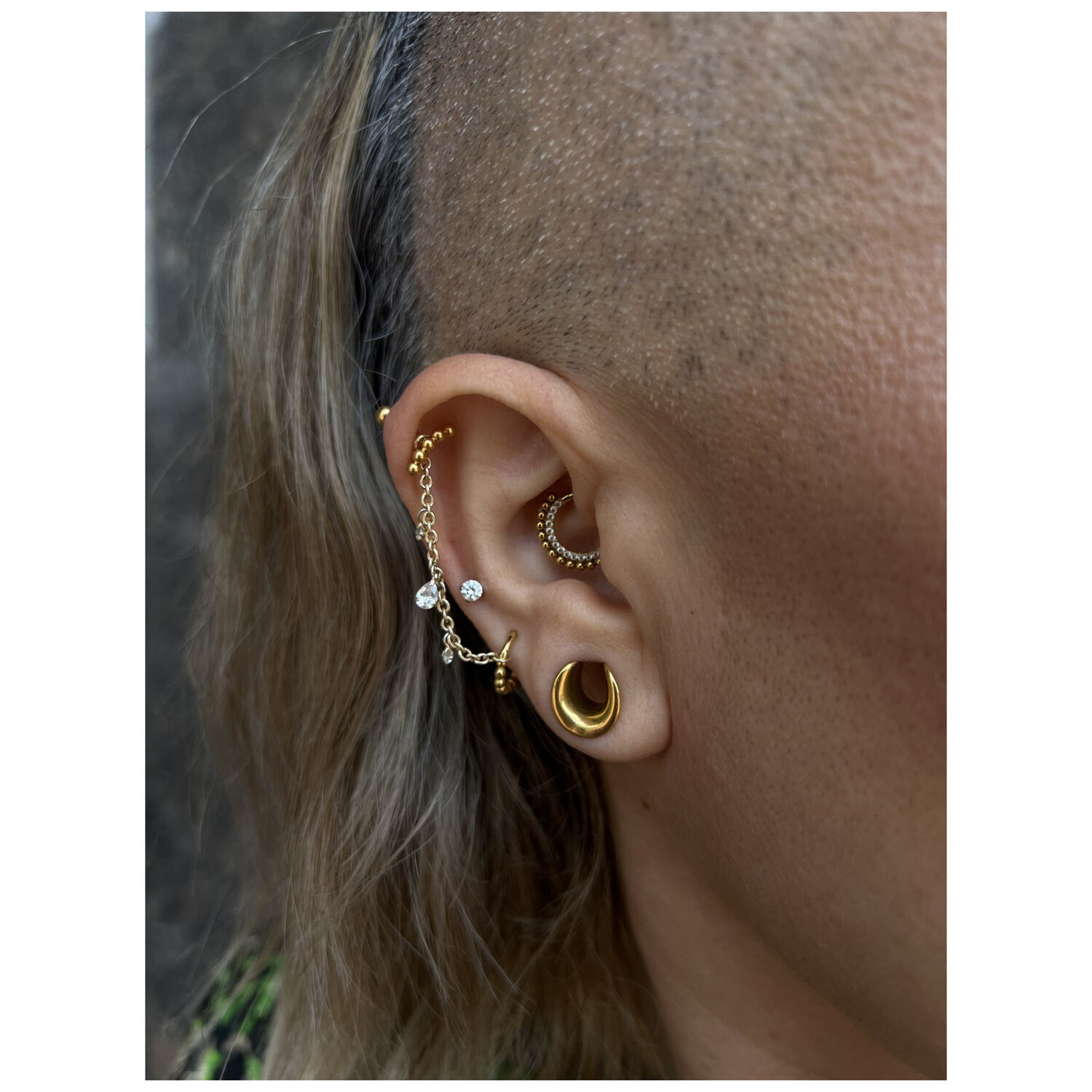 Oreille avec chaîne de piercing dorée et argentée, cristal clair