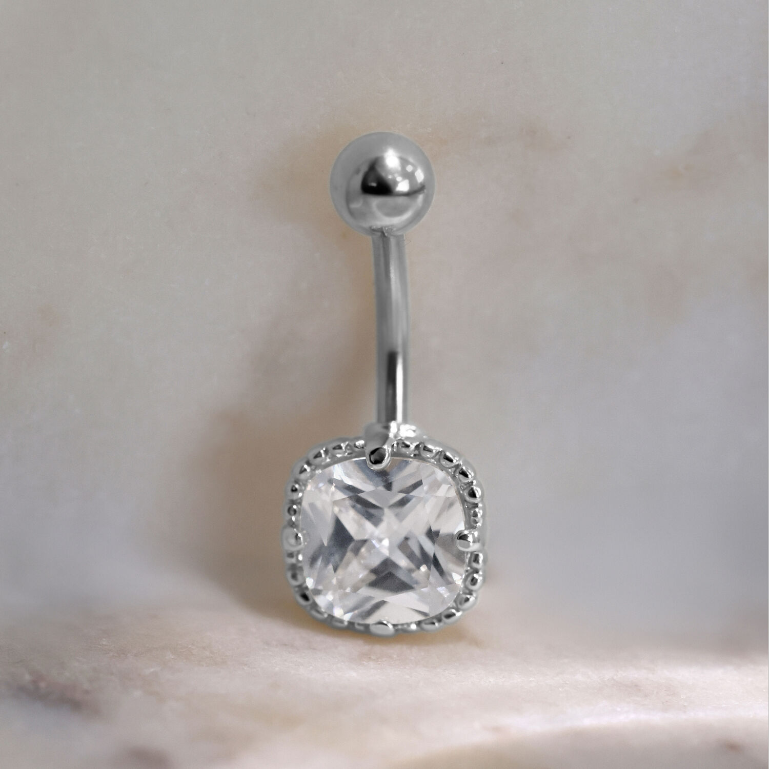 Piercing Bananabell en argent avec cristal carré sur fond marbré