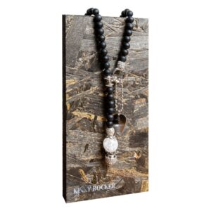 Panneau en bois avec chaîne de perles noires, détails argentés et pendentif sur fond texturé